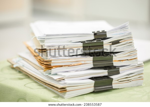 Stack of\
business report paper files with black clips\
