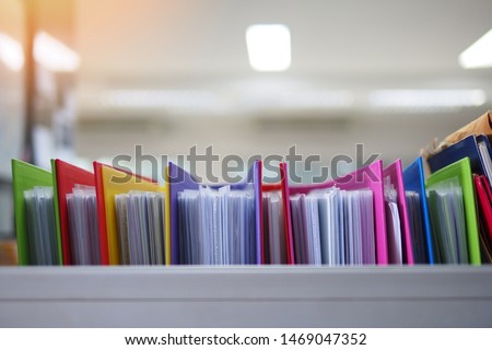 Stack or cabinet of document files in the office, business, finance, or education concept picture of pile of colorful files of papers in the business firm or company