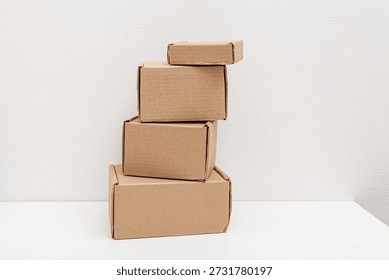 Stack of cardboard boxes of different sizes on white background. Self-assembled boxes
