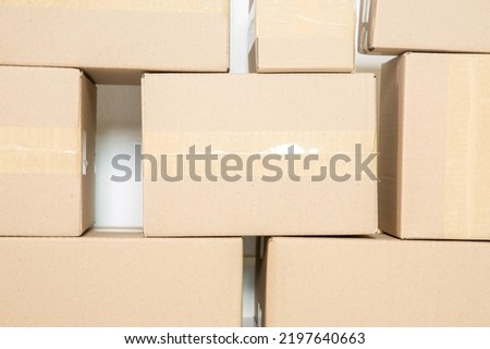 Stack of cardboard boxes for moving, Empty room with a white wall and cardboard boxes with unbranded barcode on the floor. Delivery of goods, shopping. Cardboard boxes on gray wall background.