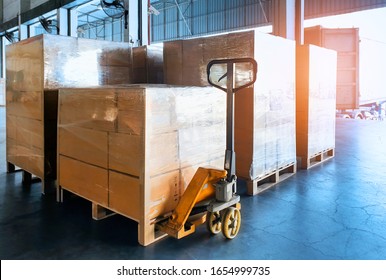 Stack cardboard boxes wrapping plastic on pallets and hand pallet truck, package boxes, loading freight truck , warehouse industrial service logistics, shipment goods transport