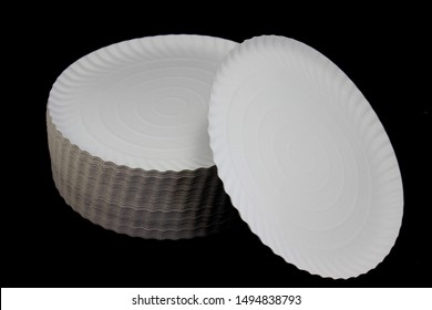 stack of cardboard plates isolated on black background. disposable dishes