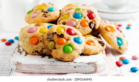 Stack Of Children's Cookies With Colorful Chocolate Candies In A Sugar Glaze On A White Light Wooden Background. Selective Focus.