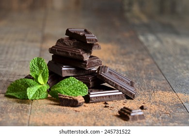 Stack of chocolate slices with mint leaf on a wooden table. - Powered by Shutterstock