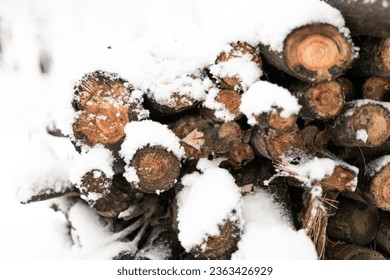 A stack of chopped firewood stacked outside in winter - Shutterstock ID 2363426929