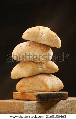 Stack of a ciabatta bread or bun on a wooden board . Freshly baked traditional bread. Shallow depth of field