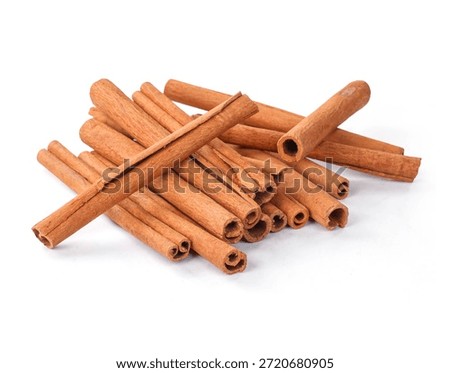 Stack of cinnamon quills on a white ceramic plate. Fragrant seasoning for flavoring sweet and savory dishes. Macro food photography.