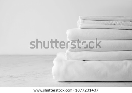 Stack of clean bed sheets on table