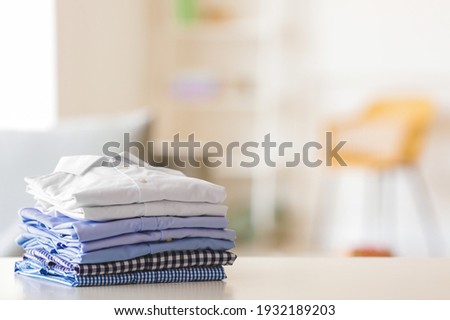 Stack of clean clothes on table in room