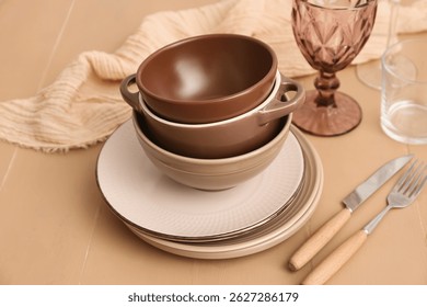 Stack of clean dishes on beige wooden background