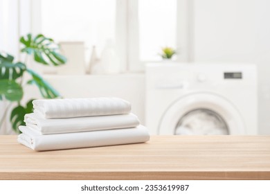 Stack of clean laundry bedding sheets on table in bathroom - Powered by Shutterstock