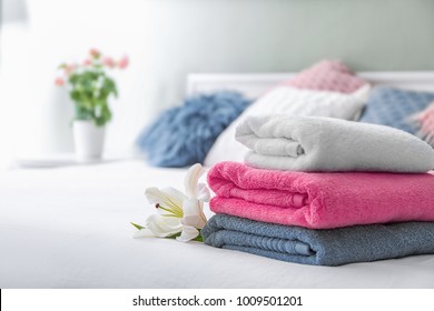 Stack of clean towels on bed - Shutterstock ID 1009501201