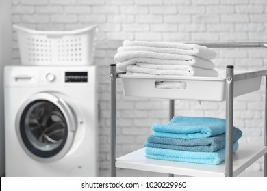 Stack of clean towels on cart in laundromat - Powered by Shutterstock