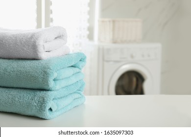 Stack Of Clean Towels On Table In Laundry Room. Space For Text