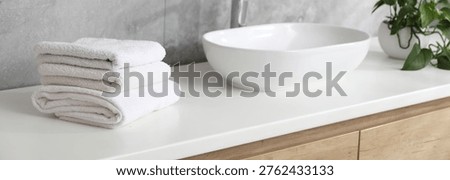 Stack of clean towels on vanity in bathroom, closeup