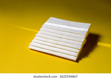 A stack of clean, white dry tissues arranged neatly on a surface. Soft texture and hygienic appearance, ideal for personal care, hygiene, or household use. Minimalist background emphasizes cleanlines