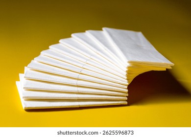 A stack of clean, white dry tissues arranged neatly on a surface. Soft texture and hygienic appearance, ideal for personal care, hygiene, or household use. Minimalist background emphasizes cleanlines