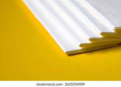 A stack of clean, white dry tissues arranged neatly on a surface. Soft texture and hygienic appearance, ideal for personal care, hygiene, or household use. Minimalist background emphasizes cleanlines