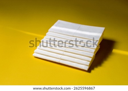 A stack of clean, white dry tissues arranged neatly on a surface. Soft texture and hygienic appearance, ideal for personal care, hygiene, or household use. Minimalist background emphasizes cleanlines