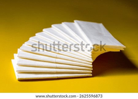 A stack of clean, white dry tissues arranged neatly on a surface. Soft texture and hygienic appearance, ideal for personal care, hygiene, or household use. Minimalist background emphasizes cleanlines