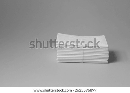 A stack of clean, white dry tissues arranged neatly on a surface. Soft texture and hygienic appearance, ideal for personal care, hygiene, or household use. Minimalist background emphasizes cleanlines