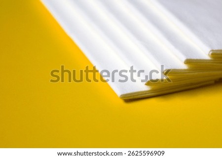 A stack of clean, white dry tissues arranged neatly on a surface. Soft texture and hygienic appearance, ideal for personal care, hygiene, or household use. Minimalist background emphasizes cleanlines