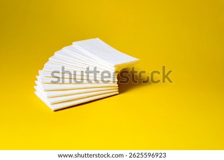A stack of clean, white dry tissues arranged neatly on a surface. Soft texture and hygienic appearance, ideal for personal care, hygiene, or household use. Minimalist background emphasizes cleanlines
