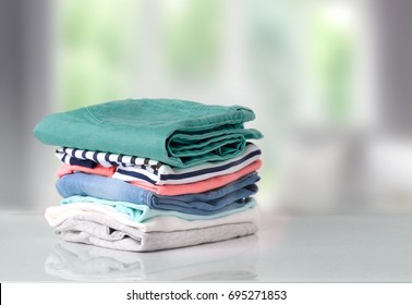 Stack of clothes on table indoor.Household concept.Fresh folded cotton clothing. - Shutterstock ID 695271853