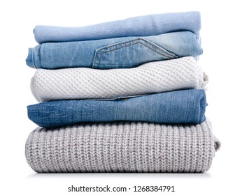 Stack of clothing jeans sweaters on a white background isolation - Shutterstock ID 1268384791