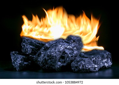Stack of coal lumps and fire on black background