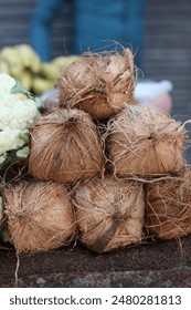 A stack of coconuts at a vegetable stall