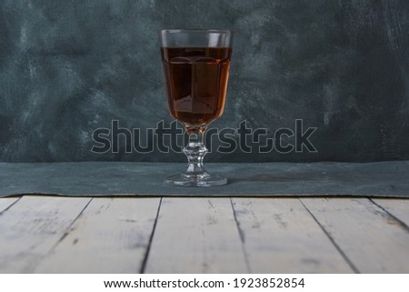 Stack of cognac on leg on dark background. Drinking alone in bar. Alcoholism as bad habit. Strong drinks in shot glass