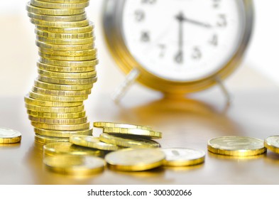 A stack of coins and alarm clock