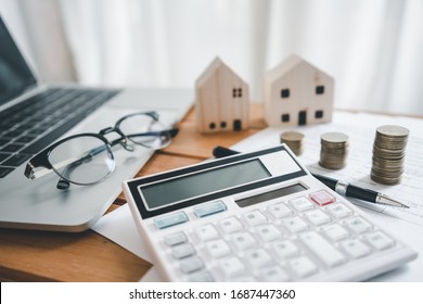 Stack Of Coins With Calculator,House Model,tax Form,glasses And Tablet,Income Tax Raise Concept.

