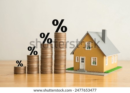 Stack coins as graph trend up and interest rates with house model background. FED fix recession inflation crisis by increase interest rate that effect to house buyer. Mortgage loan, financial concept.