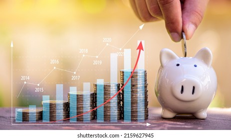 Stack Of Coins With Growing Income Profit Graph And Saving Word. Investor Put Coin Step To Piggy Bank, Investment, Saving, Banking, Tax Concept