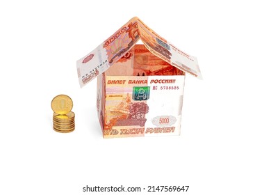 a stack of coins and a house made of Russian money, isolated on a white background