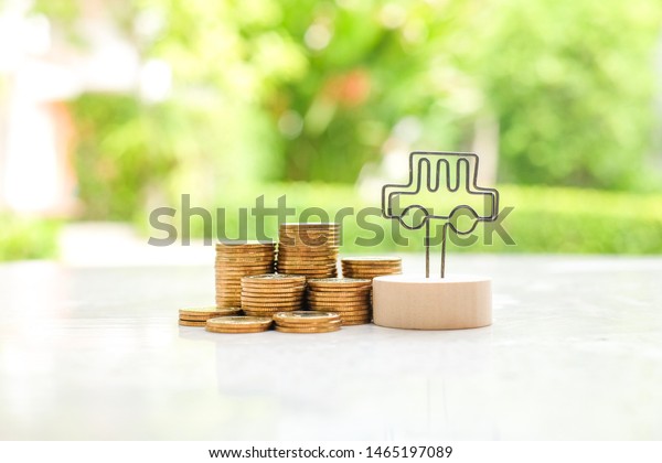 Stack of\
coins and mini car. Saving money for buy\
car.