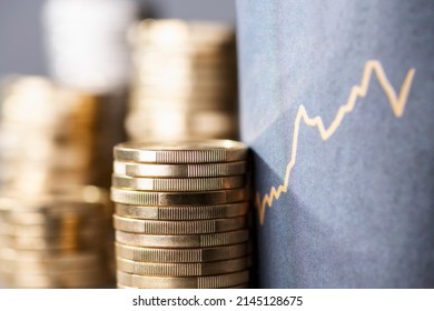 Stack of coins next to a upward curve symbolizing rising costs due to inflation - Shutterstock ID 2145128675