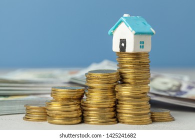 Stack Of Coins And An Old House. Concept Of Expensive Home Repair Service.