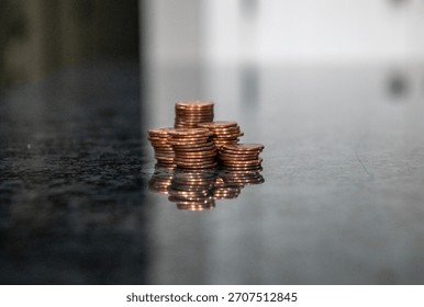 A stack of coins on a marble counter represents the demise of the penny due to the Treasury Department, which has stopped minting pennies. 