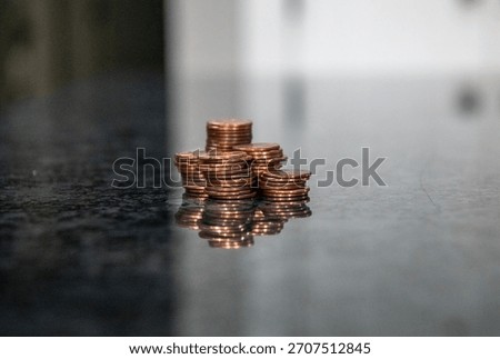 A stack of coins on a marble counter represents the demise of the penny due to the Treasury Department, which has stopped minting pennies. 