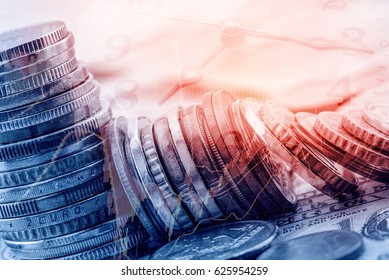 Stack of coins on US dollar notes with analog clock hands and a technical chart of financial instruments. Concept of time value of money, any amount of money is worth more the sooner it is received. 