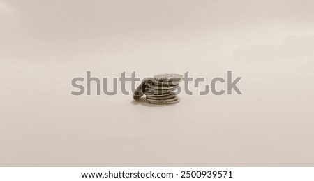 Stack of coins precariously balanced, symbolizing financial instability and the concept of risk in monetary matters.