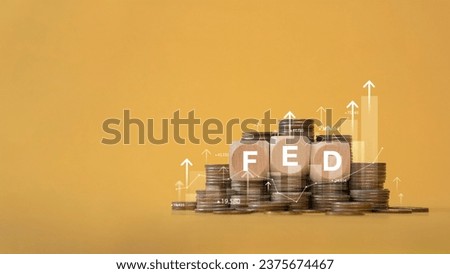 Stack of coins and wooden blocks with FED and graph up. Stack of coins with graph chart growth up, Business marketing. Idea of raising interest rates by the Fed to reduce inflation. economy business