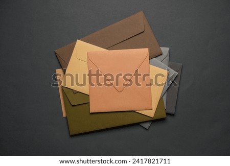 Stack of colored envelopes on dark gray background