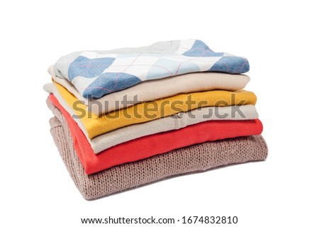 Stack of coloreful sweaters on the white background.
