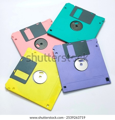 A stack of colorful 3.5 inch floppy disks on a white background. These vintage computer storage devices were popular in the 1990s.