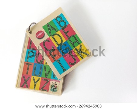 Stack of colorful alphabet learning flash cards for preschool education on white background.
