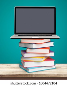 Stack Of Colorful Books Collection And A Laptop On The Desk